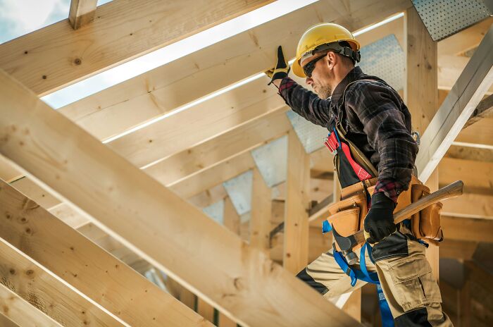 A construction worker building a roof, illustrating how people are getting scammed in the construction industry.