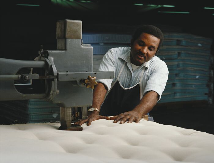A worker in an industry operating machinery on a mattress, representing the various ways people are getting scammed.