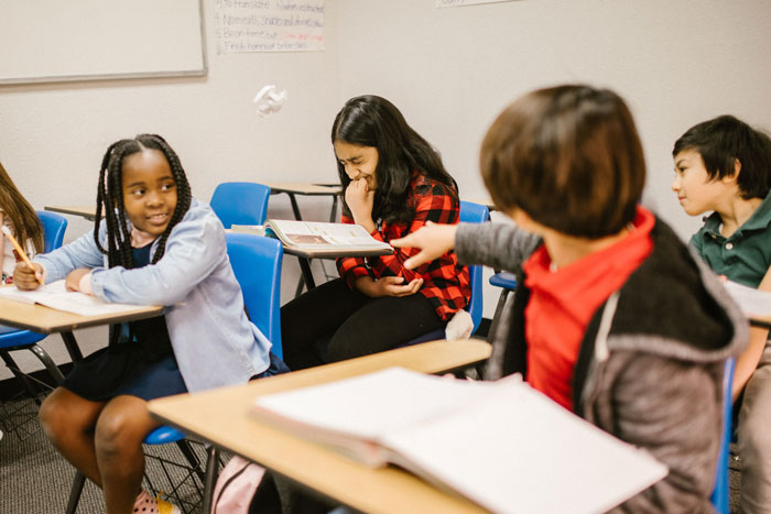 A classroom scene where a student points at another, depicting a red flag student scenario that teachers can spot.