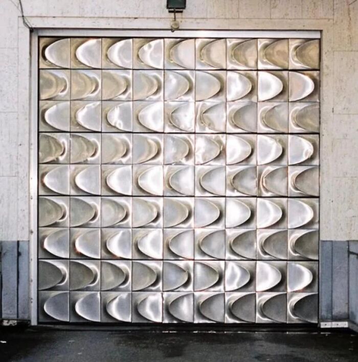 Remarkable Designs: A metallic door with a unique textured pattern, showcasing iconic design and historic interiors.