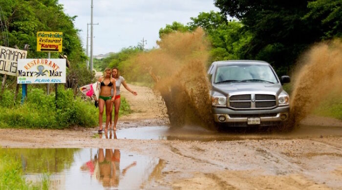Hilarious photo of a car splashing mud on two women, moments before disaster struck.