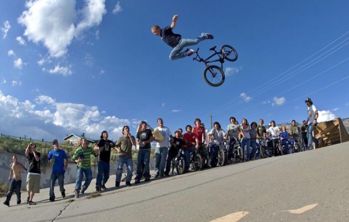 A bicyclist mid-air during a trick, with a crowd watching, moments before disaster struck.
