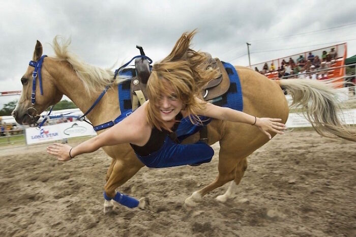 A woman riding a horse at high speed, leaning off the side, moments before disaster struck.
