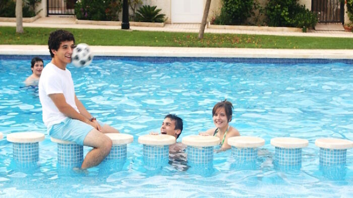 A group of people in a pool as a soccer ball approaches, a hilarious photo taken moments before disaster.