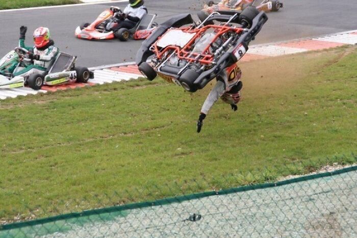 A go-kart racer is ejected as their kart flips over, a hilarious photo taken moments before disaster.