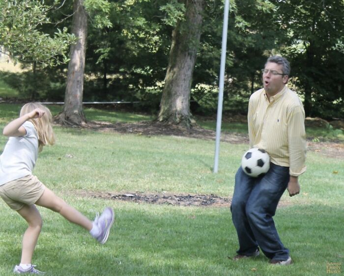 A child kicking a soccer ball directly into an adult man's groin, a hilarious photo before disaster struck.
