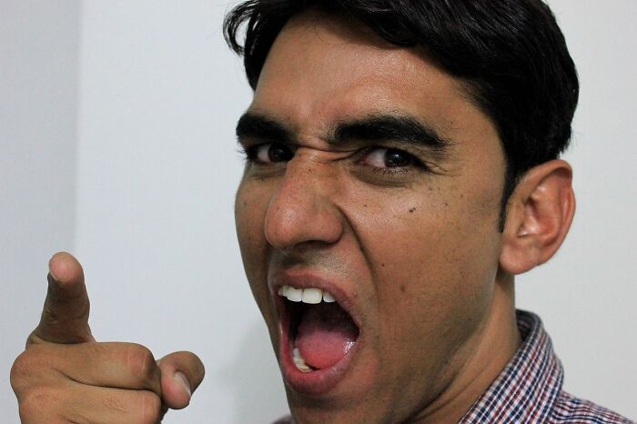 A man yelling and pointing, reflecting psycho moments from partners.