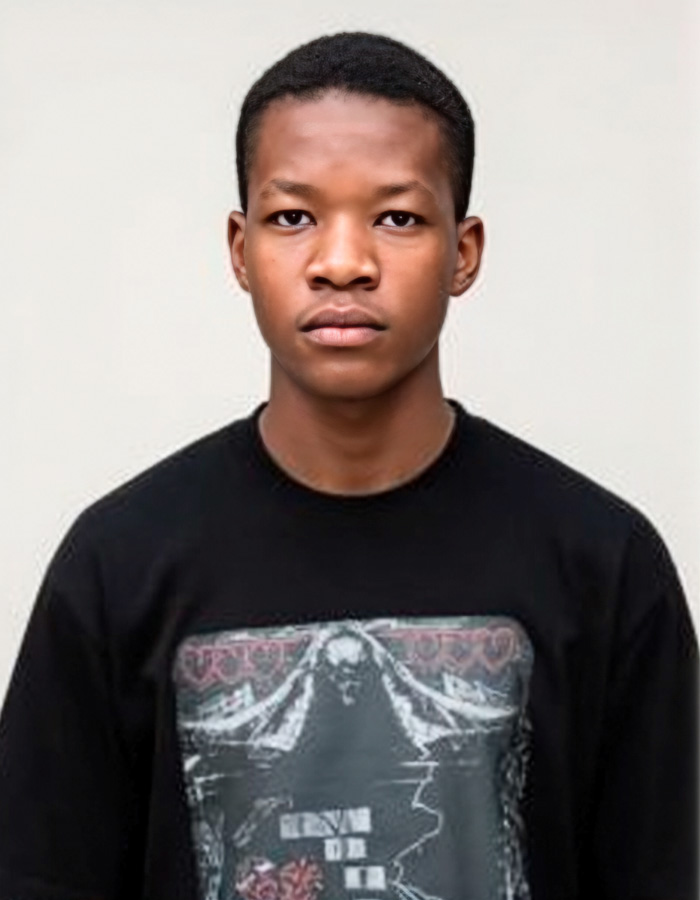 A serious young man in a black t-shirt, reflecting on unthinkable sibling disputes and their tragic outcomes.