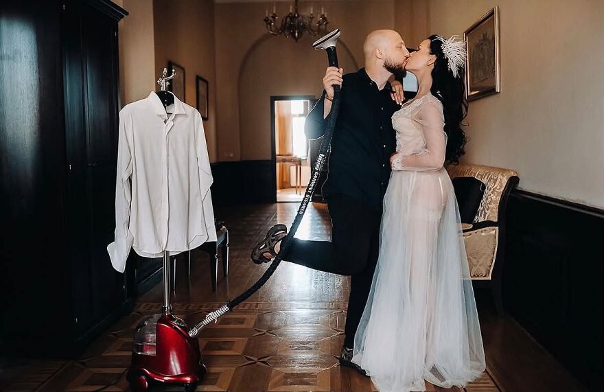 A groom holding a steamer and kissing his bride in a funny wedding photo.