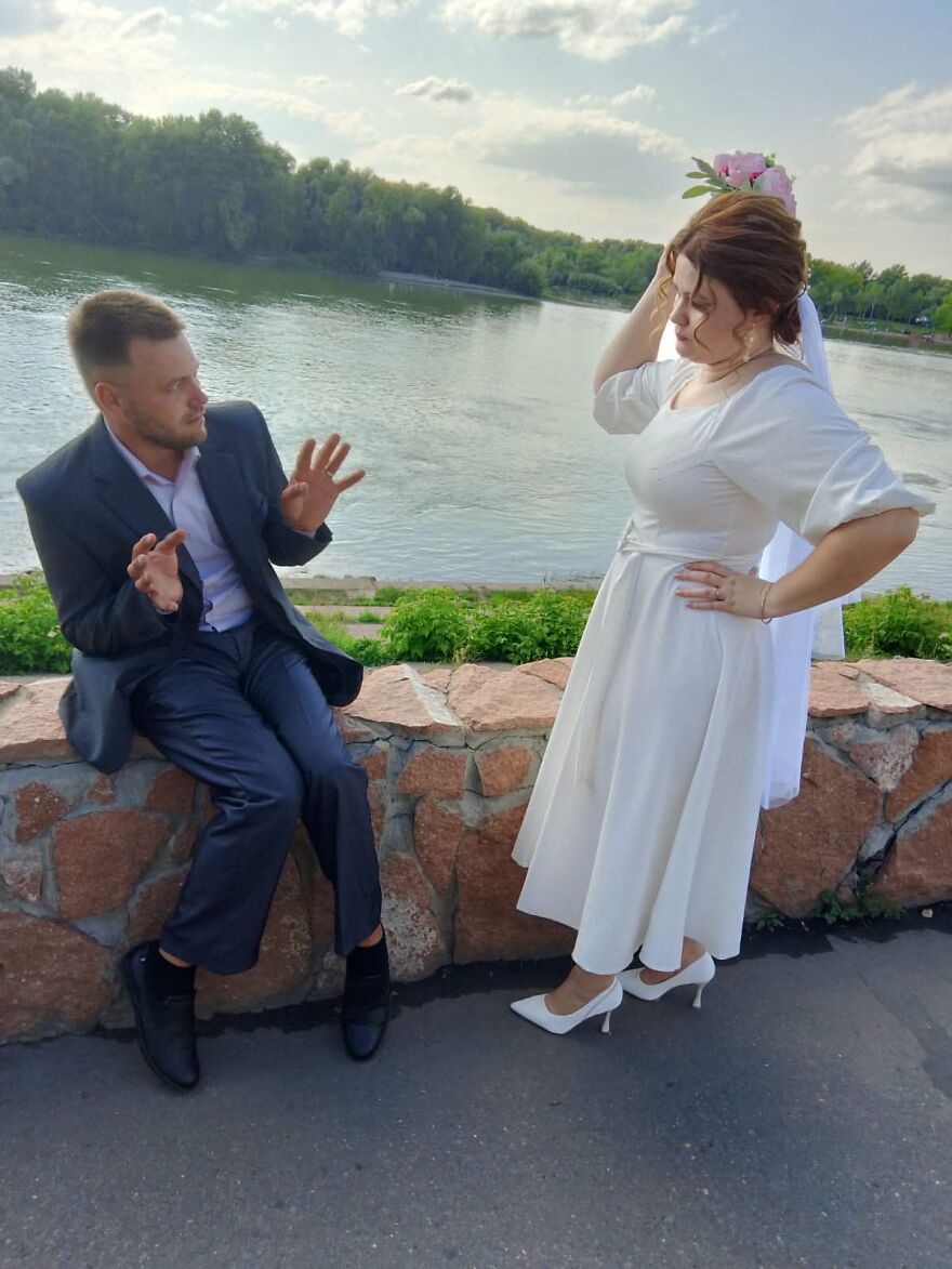 A bride and groom in a funny pose by the water, capturing silly wedding photos with their expressions.