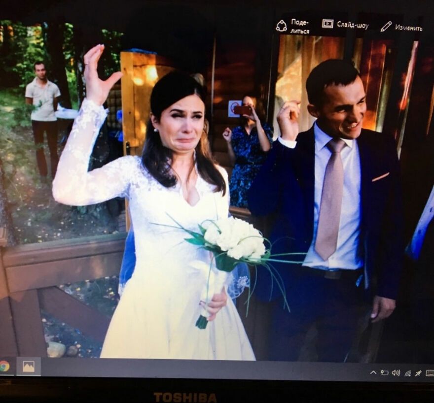 A bride making a funny face while the groom smiles, capturing a silly wedding photo.