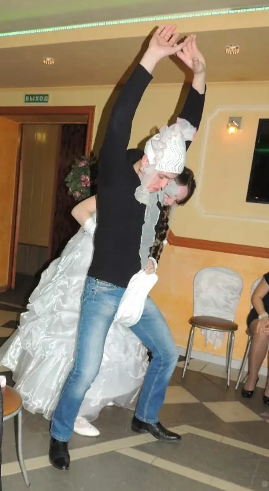 A groom lifting a bride playfully, creating a funny wedding photo moment.
