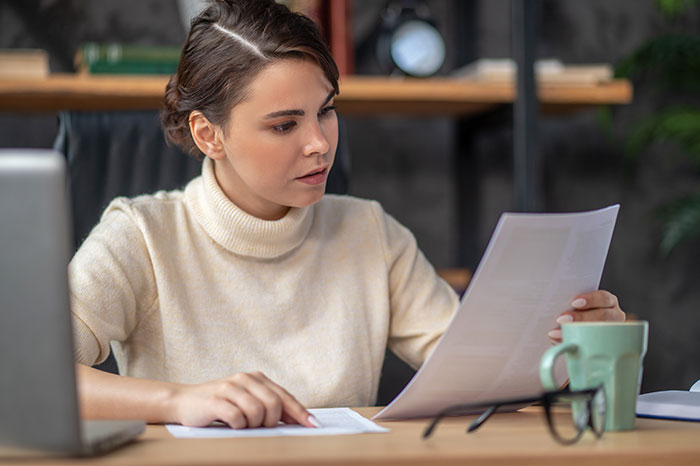 Woman reading documents, discovering sister received her college fund. Woman wants an apology for college fund. Woman reading documents, discovering sister received her college fund. Woman wants an apology for college fund.