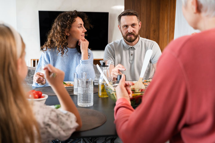 A family at a table, discussing the bride's decision to ban the service dog from her wedding.