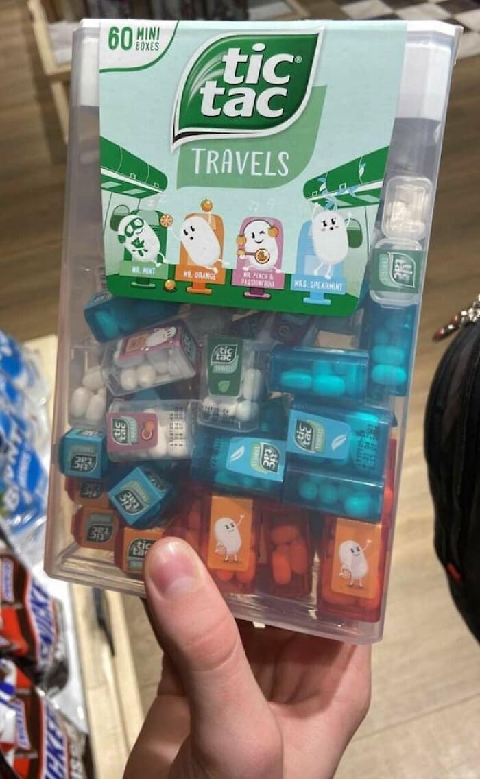 A hand holding a giant Tic Tac container, illustrating the true scale of mini boxes.