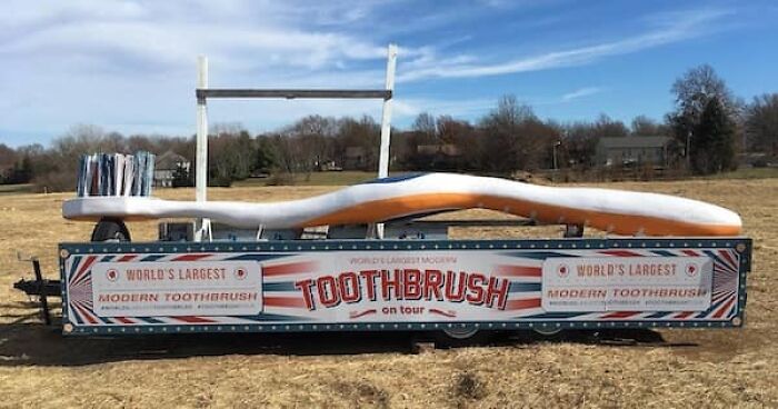 The world's largest modern toothbrush on a trailer, a striking size comparison of an everyday item.