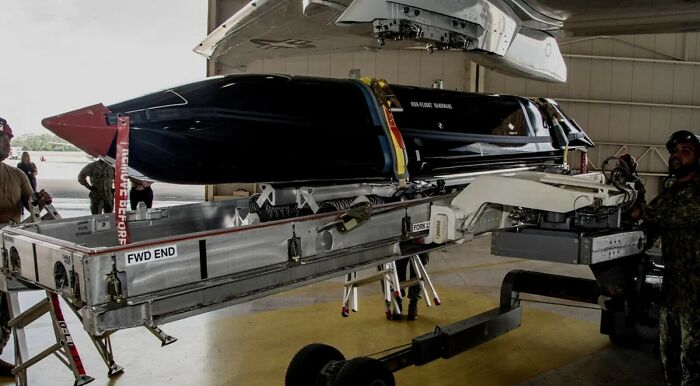 Workers preparing a large missile, showcasing the true scale and size comparison of modern weaponry.