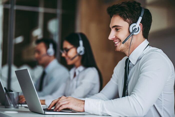A group of socially awkward people in an office, working with headsets, reflecting on cringe moments.