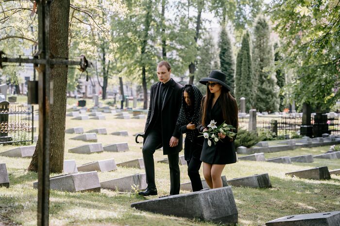 A group of socially awkward people walking through a graveyard, experiencing cringe moments.