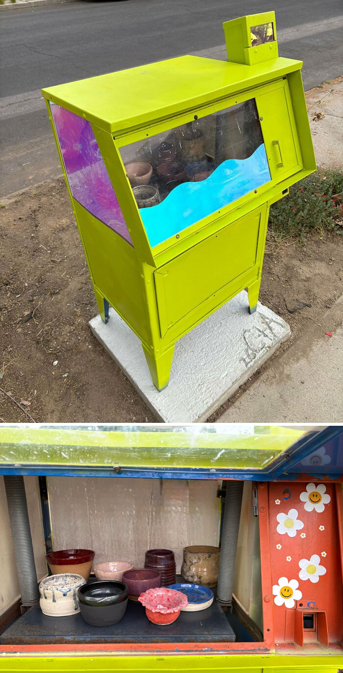 A repurposed green newspaper stand transformed into a tiny art gallery, a magical handmade project.