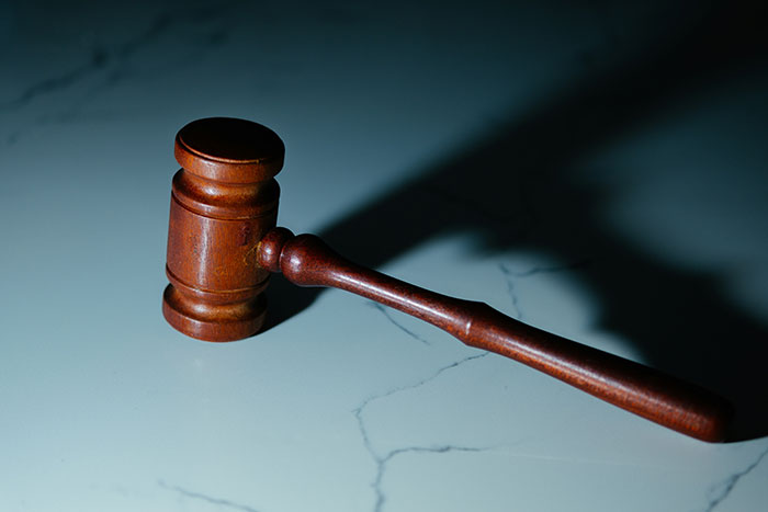 A wooden gavel, symbolizing the law and instant karma in divorce cases, rests on a marble surface.