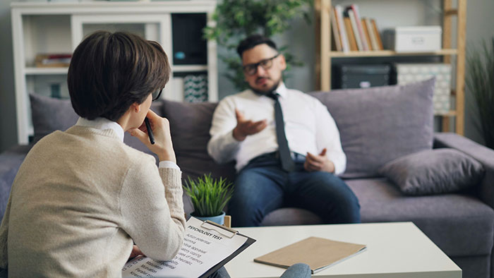 A man speaking to a professional, possibly a divorce lawyer, sharing stories of instant karma.
