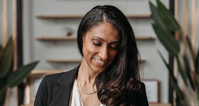 A smiling female divorce lawyer, demonstrating satisfaction, potentially from a case of instant karma.
