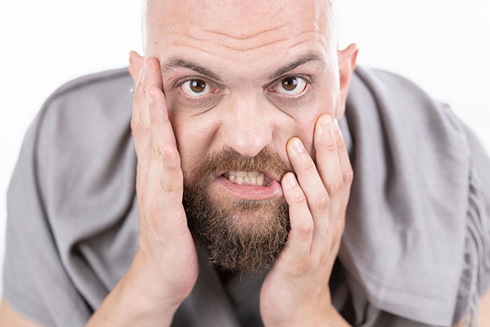A frustrated man with a beard and bald head, expressing anger, reflecting on instant karma in divorce.