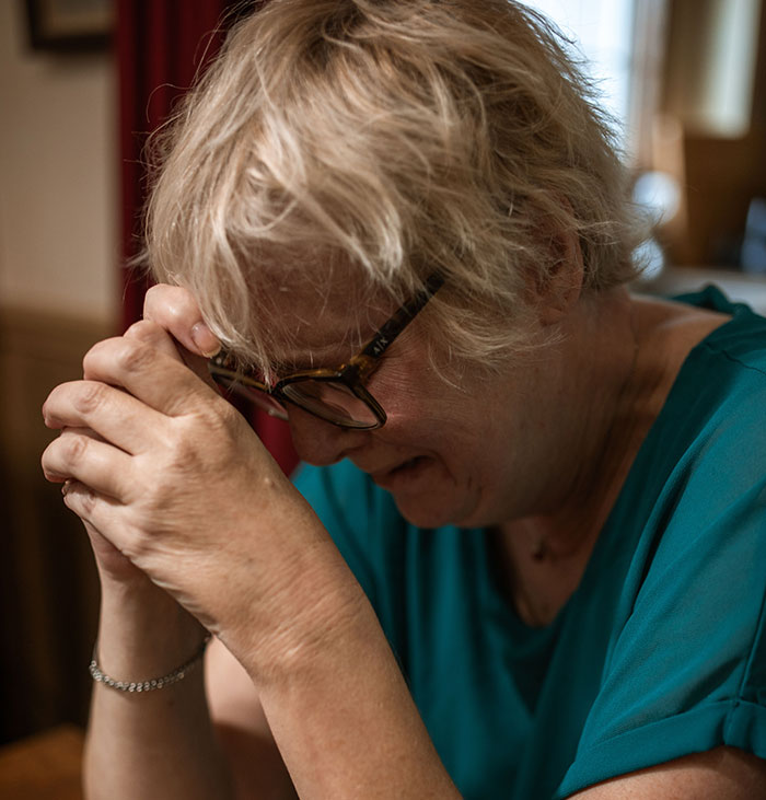 An older woman with blonde hair, possibly involved in a divorce, shows distress, related to instant karma.