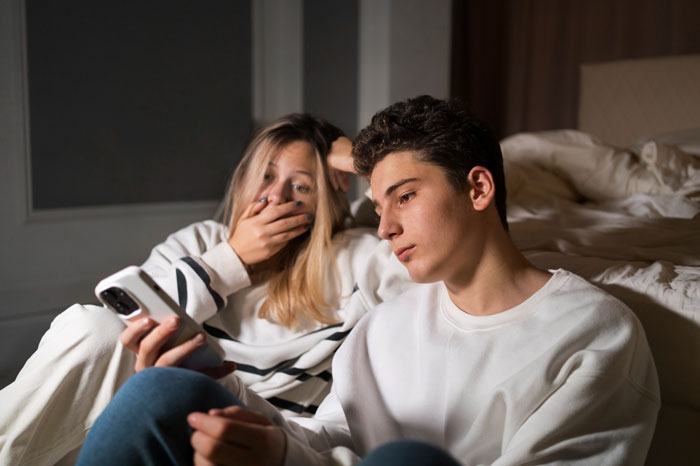 Concerned teens looking at a phone, discovering a spy camera in room by step-dad. Concerned teens looking at a phone, discovering a spy camera in room by step-dad.