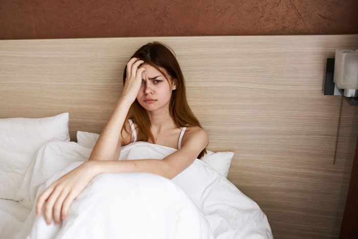 A distressed young woman in bed, symbolizing the feelings associated with a spy camera in her room by her step-dad. A distressed young woman in bed, symbolizing the feelings associated with a spy camera in her room by her step-dad.