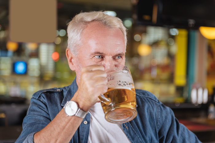 Man drinking beer, considering the age to give up beer for nervous system health.