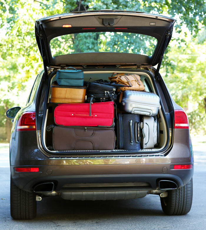 The open trunk of an SUV overflowing with various luggage, representing a moment of instant justice.
