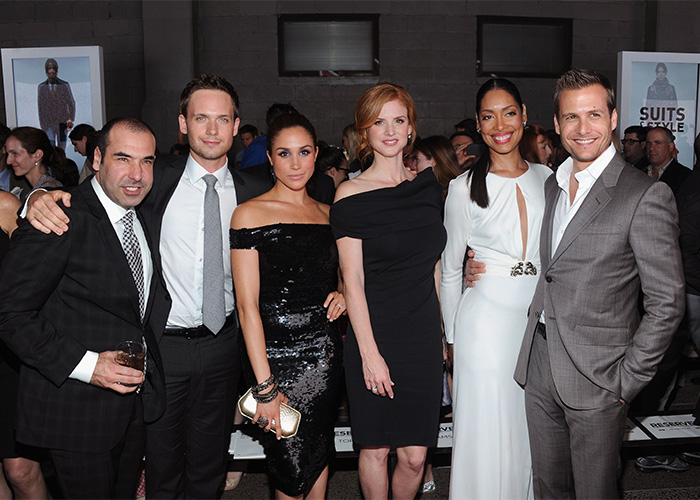 Hollywood stars at an event. A woman in a black sequin dress stands among five other actors. Hollywood stars at an event. A woman in a black sequin dress stands among five other actors.