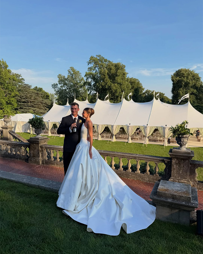 Tennis star's wife and husband at a Nantucket event with a large tent in the background.