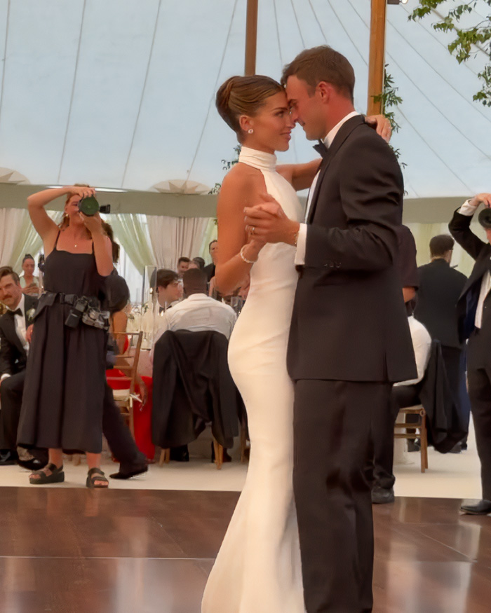 Tennis star's wife and husband dancing at a Nantucket event, amidst controversy with 'No Influencers' sign.