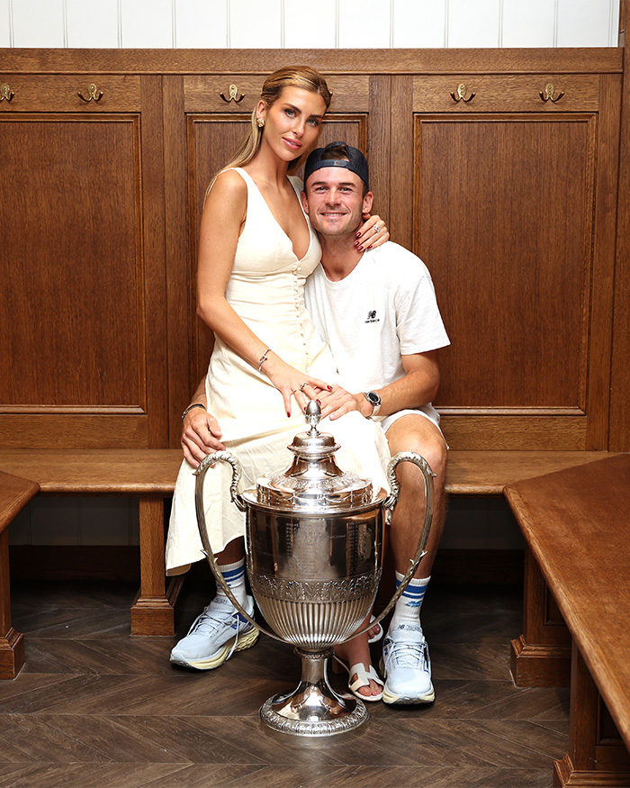 Tennis star and his wife sitting with a trophy, exposing Nantucket Store with 'No Influencers' sign.