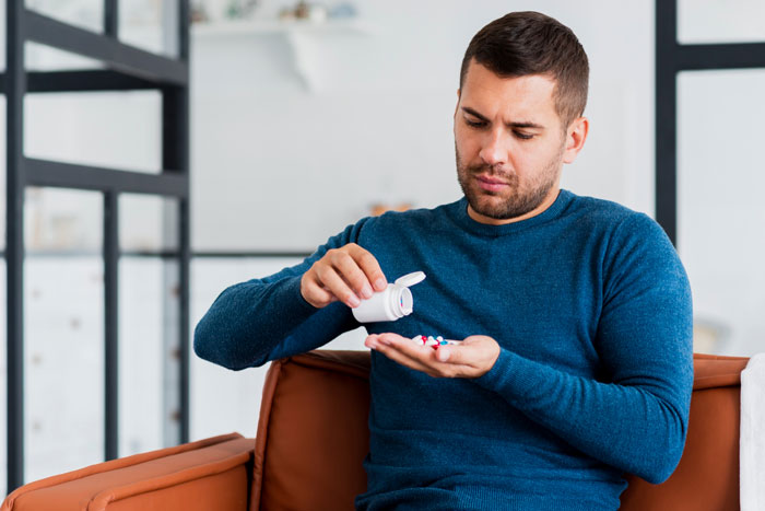 Man holding pills symbolizing medication effects on love life