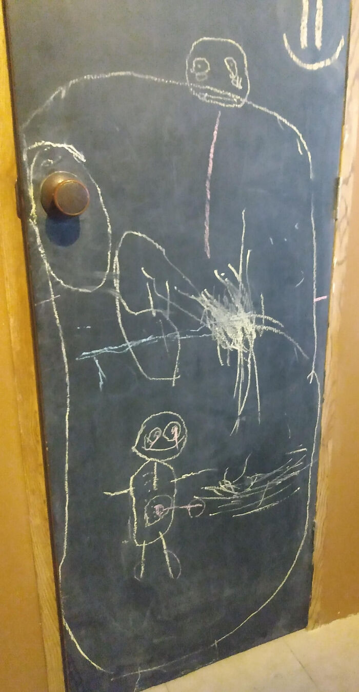 Chalk drawings on a dark door, showing figures that could make parents terrified.
