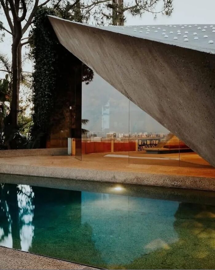 Remarkable historic interiors featuring a modern concrete and glass building next to a pool, iconic furniture.