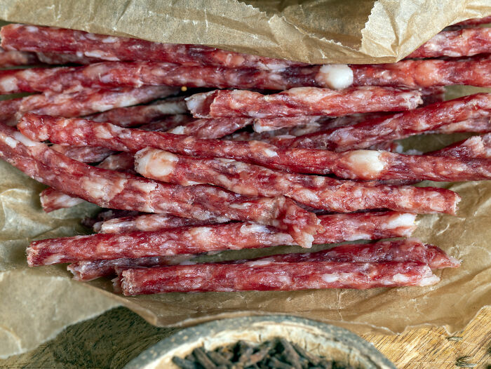 Close-up of numerous trendy snack food sticks on brown paper, highlighting the texture and appearance.