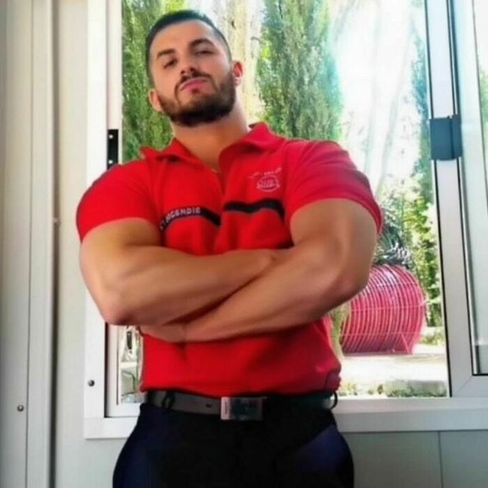 Before his transformation, a man poses with arms crossed, in a red uniform, representing his career before becoming a Black Alien. Before his transformation, a man poses with arms crossed, in a red uniform, representing his career before becoming a Black Alien.