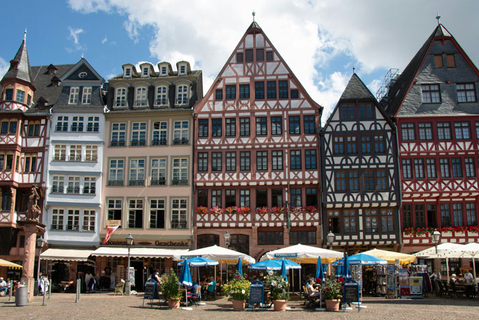 Historic half-timbered houses in a European city, exploring global responses to working in the heat.