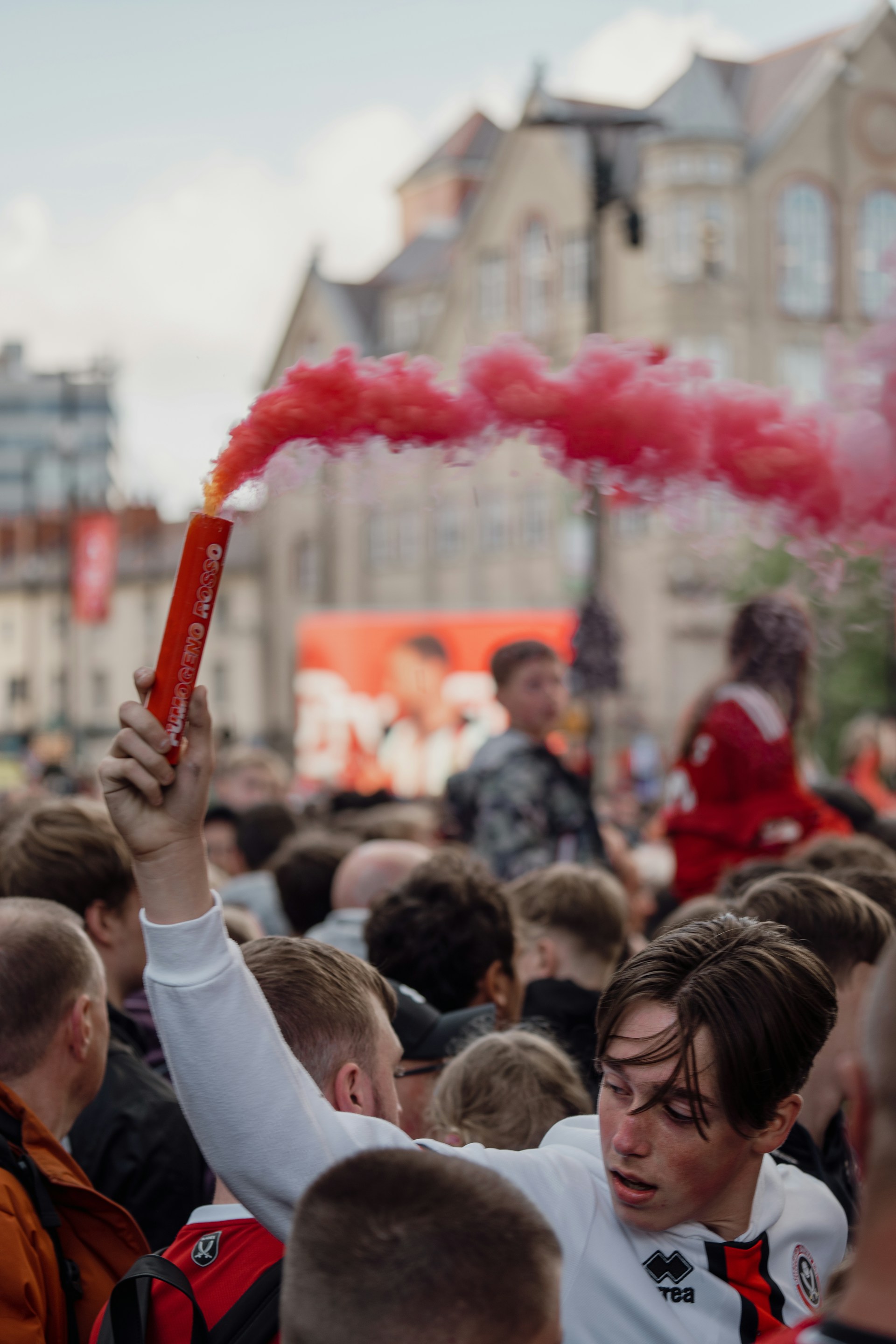 A football fan ignites a red flare during a match, showing his upset. A football fan ignites a red flare during a match, showing his upset.