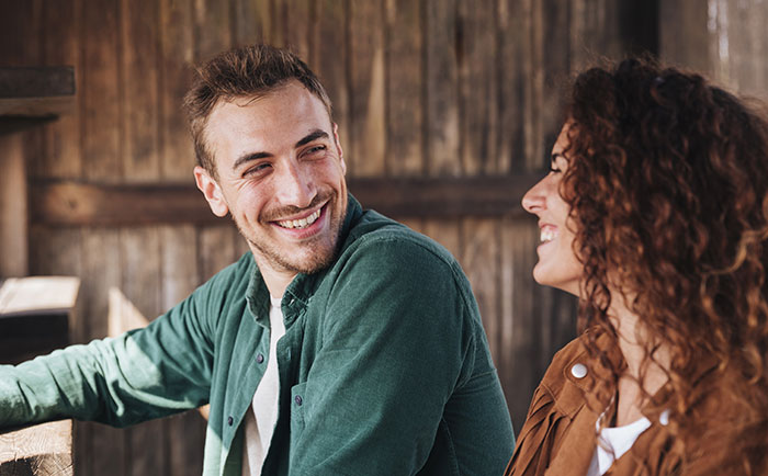 A man smiling and looking at a woman, depicting the theme of being mistaken for an identical twin. A man smiling and looking at a woman, depicting the theme of being mistaken for an identical twin.