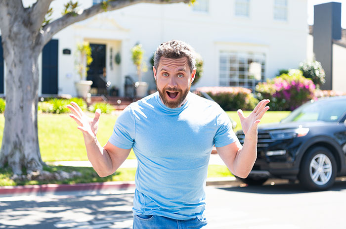 A man with a surprised expression, hands raised, after mistaking a woman for her identical twin sister. A man with a surprised expression, hands raised, after mistaking a woman for her identical twin sister.