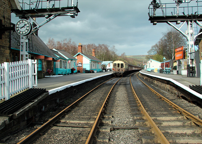 A railway station with tracks and buildings, symbolizing Britain's railway stations where women lived in fear.
