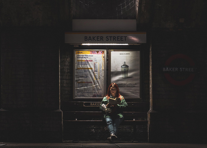 A woman sitting at Baker Street railway station, reflecting the fear women experienced near Britain's railway stations.
