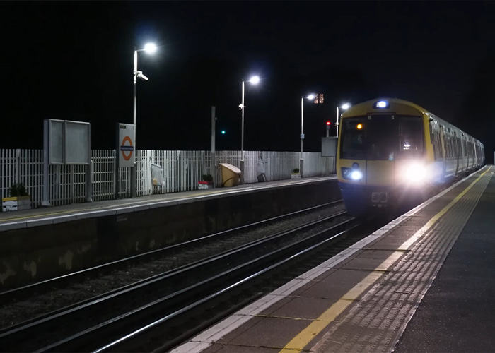 A train arriving at a railway station at night, illustrating fear near Britain's railway stations.