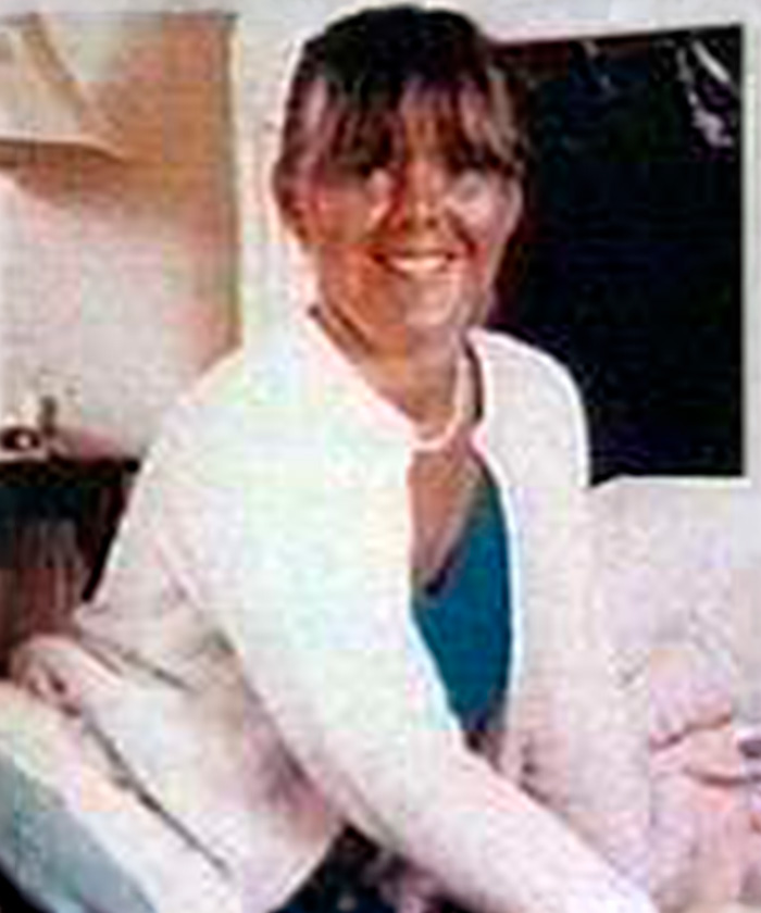 Color photo of a smiling woman, representative of women near Britains railway stations.
